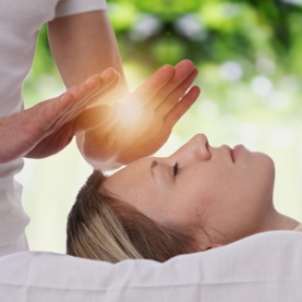 Woman having reiki healing treatment , alternative medicine concept.